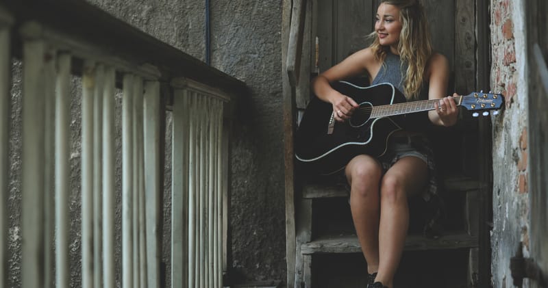 Woman Wearing Gray Tank Top Playing Black Cutaway Acoustic Guitar