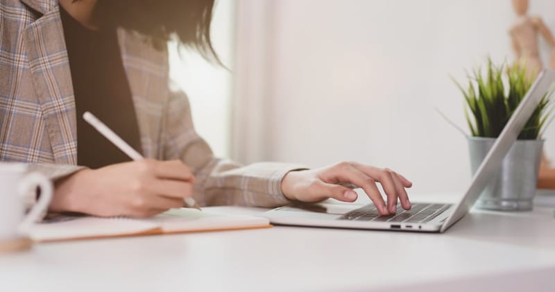 woman writing resume with strong action verbs